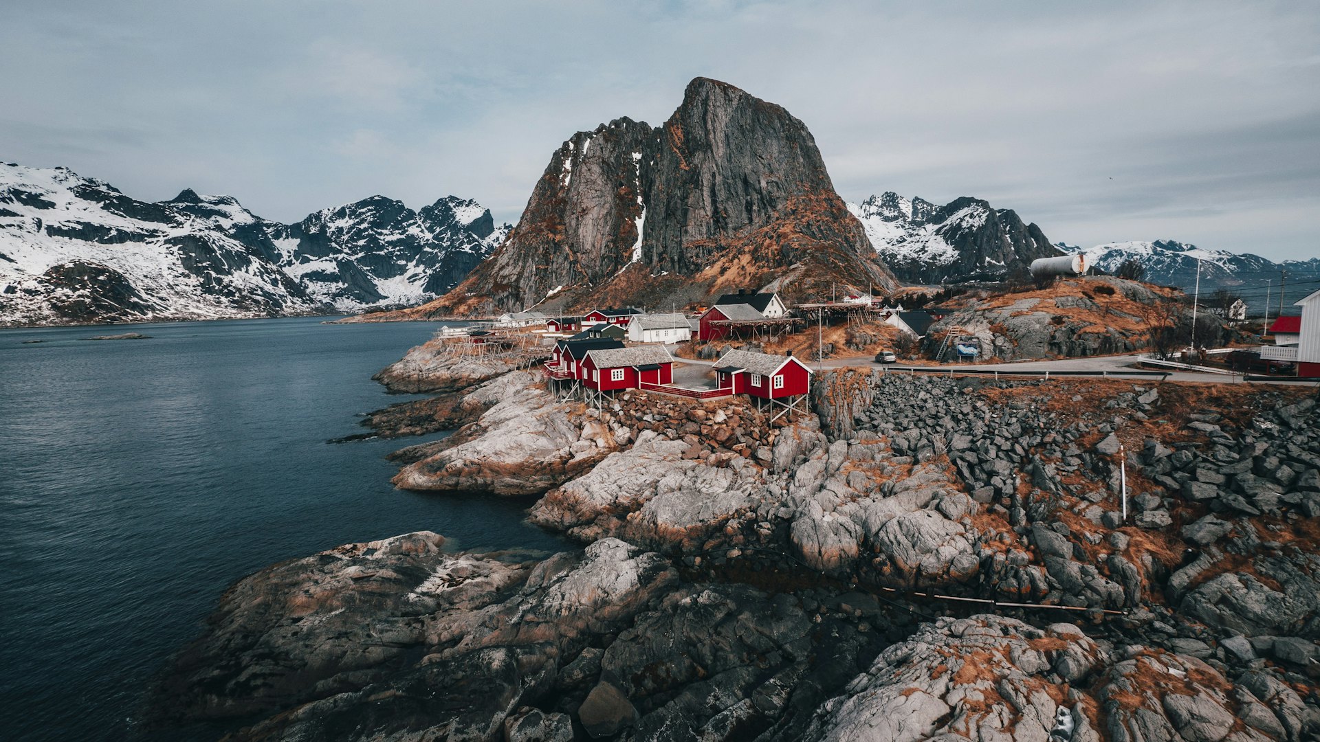 Red fishing cabins below the peaks of the Lofoten Islands